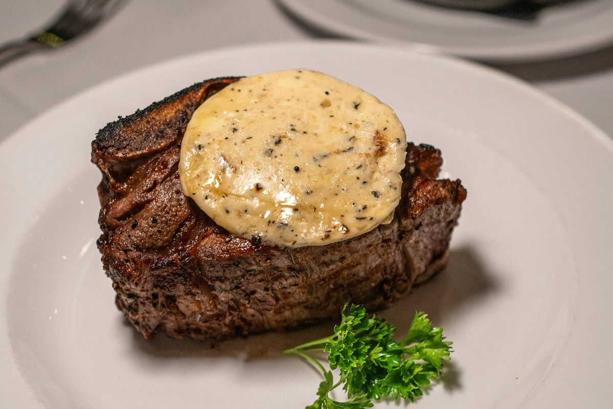 Filete de res acompañado de salsa cremosa de ajo. Foto de Pexels.