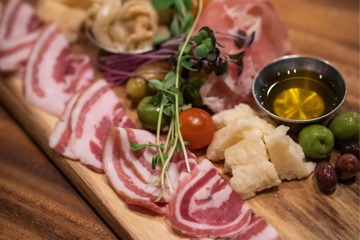 Tabla de quesos frescos y carnes frías. Foto de Pexels.