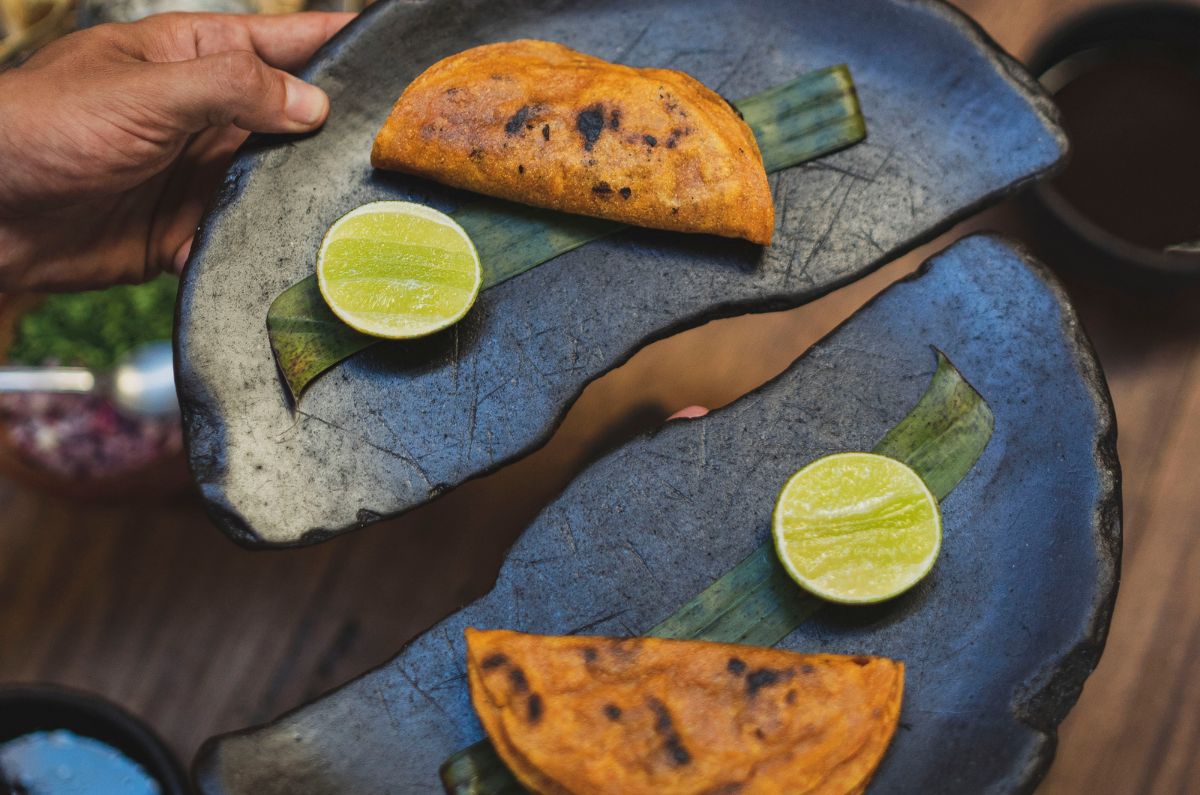 Taco dorado de birria terminado al carbón y acompañado de su consomé en Negro Huitlacoche, foto proporcionada por el restaurante