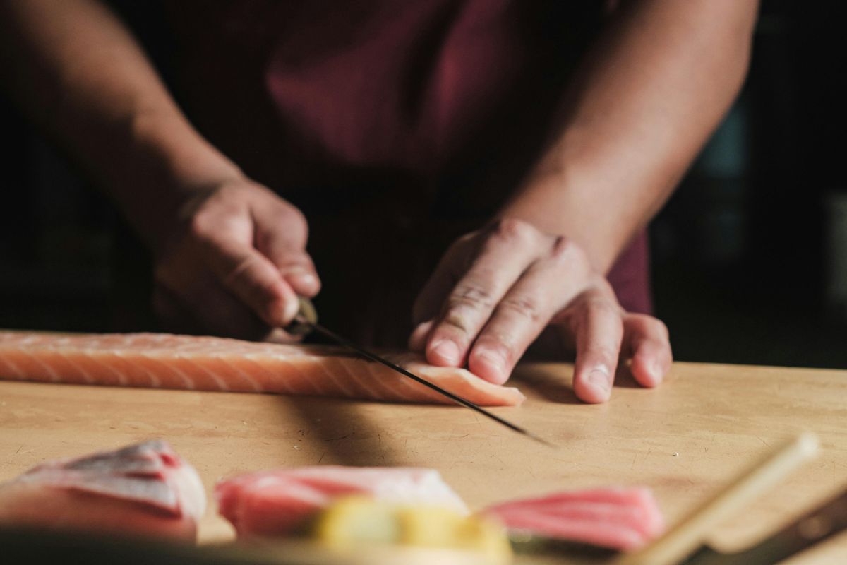 Chef rebanando salmón fresco. Foto de Pexels.