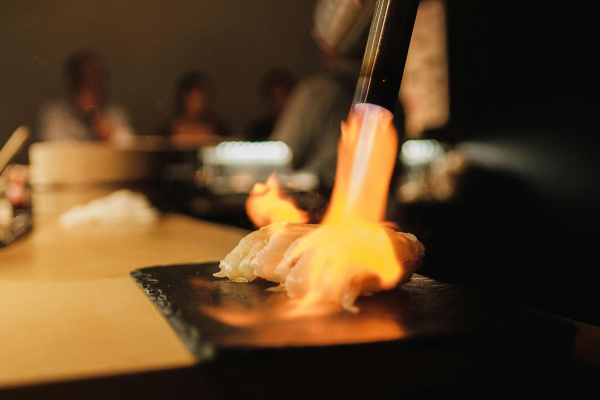 Chef flameando nigiris. Foto de Pexels.