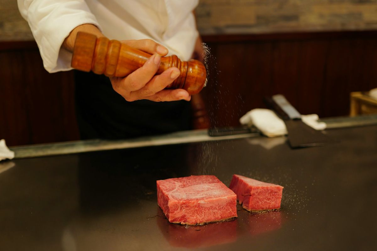 Chef sellando carne en plancha. Foto de Pexels.