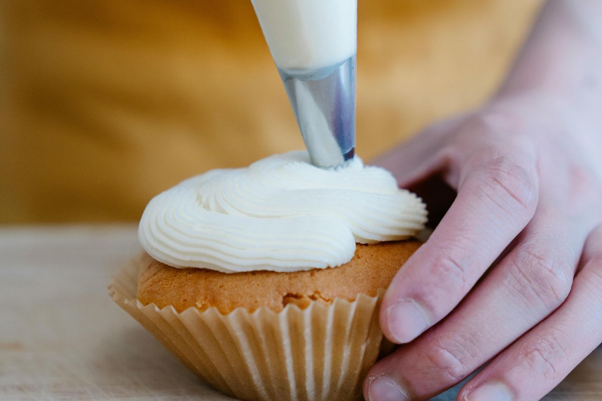 Persona decorando cupcakes. Foto de Pexels.