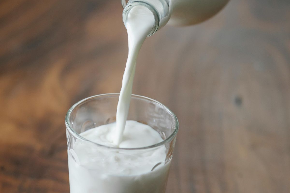 Persona sirviendo leche fresca. Foto de Pexels.