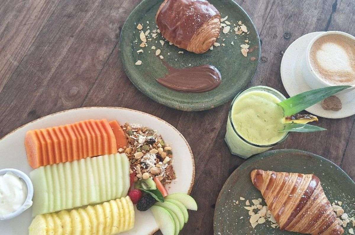 Plato de frutas de temporada con yogur y granola, pan dulce, smoothie, foto de Miriam Carmo