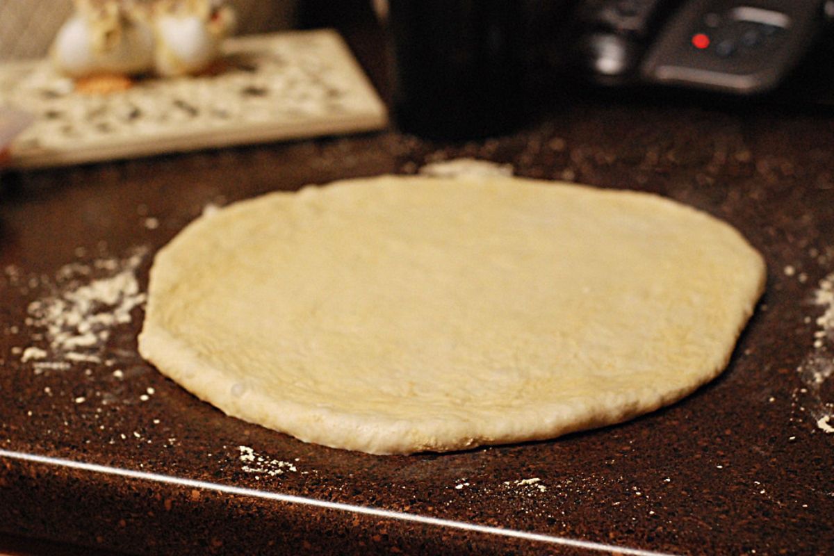 Masa extendida para preparar pizza. Foto de Pexels.