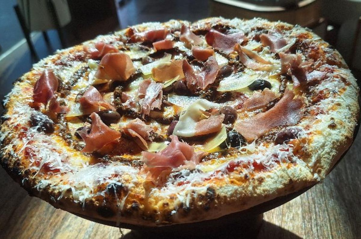 Pizza Jamón Serrano (mozzarella, aceituna negra, jamón serrano, pesto rojo y queso parmesano), foto de Miriam Carmo