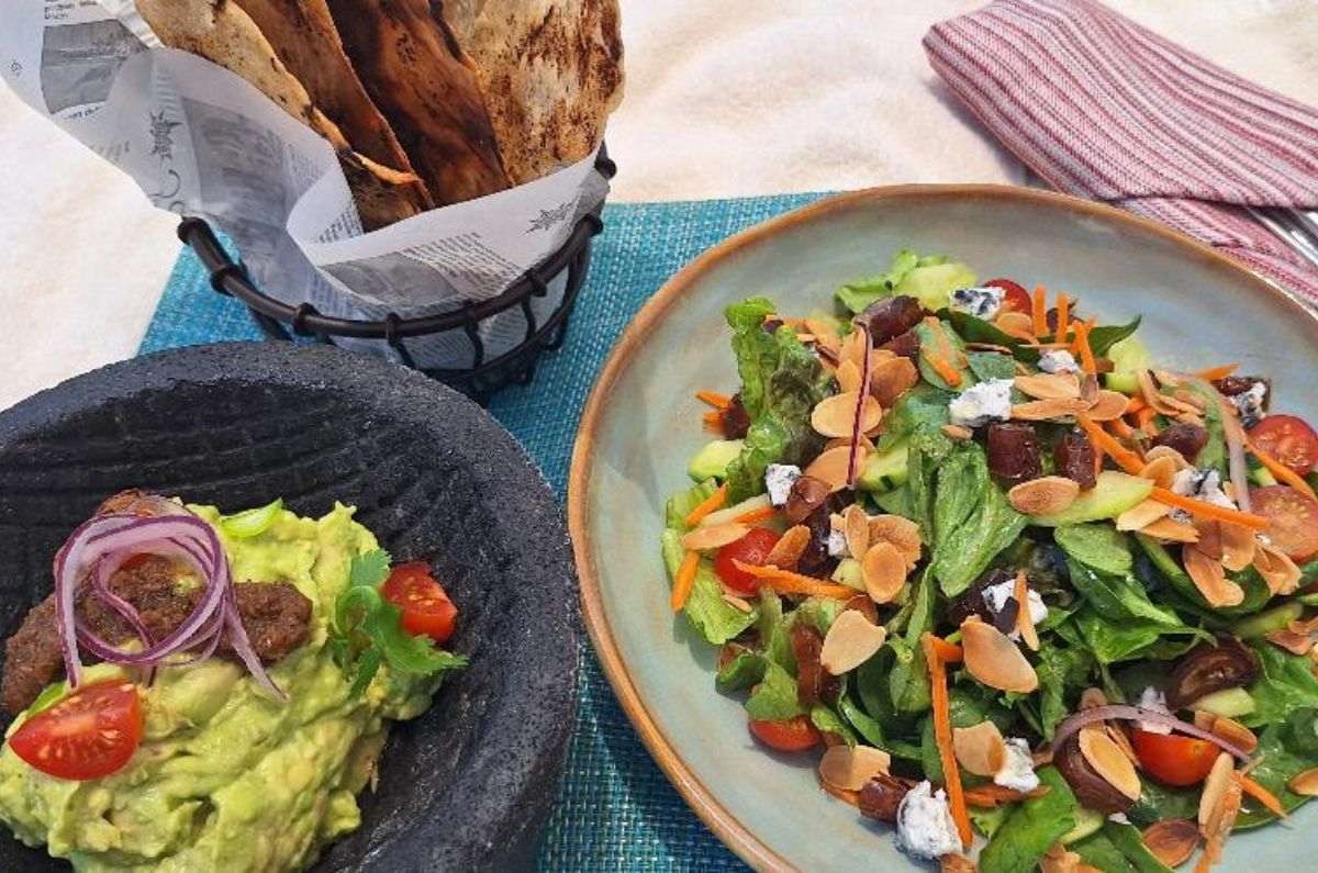 Aguacate machacado con chile fresno en escabeche, aceite de oliva, salsa tatemada y tortillas de maíz local y ensalada de dátiles con mezcla de verduras, almendras tostadas, queso de cabra de Valladolid, aderezo de mostaza Dijon y miel de agave, foto de Miriam Carmo