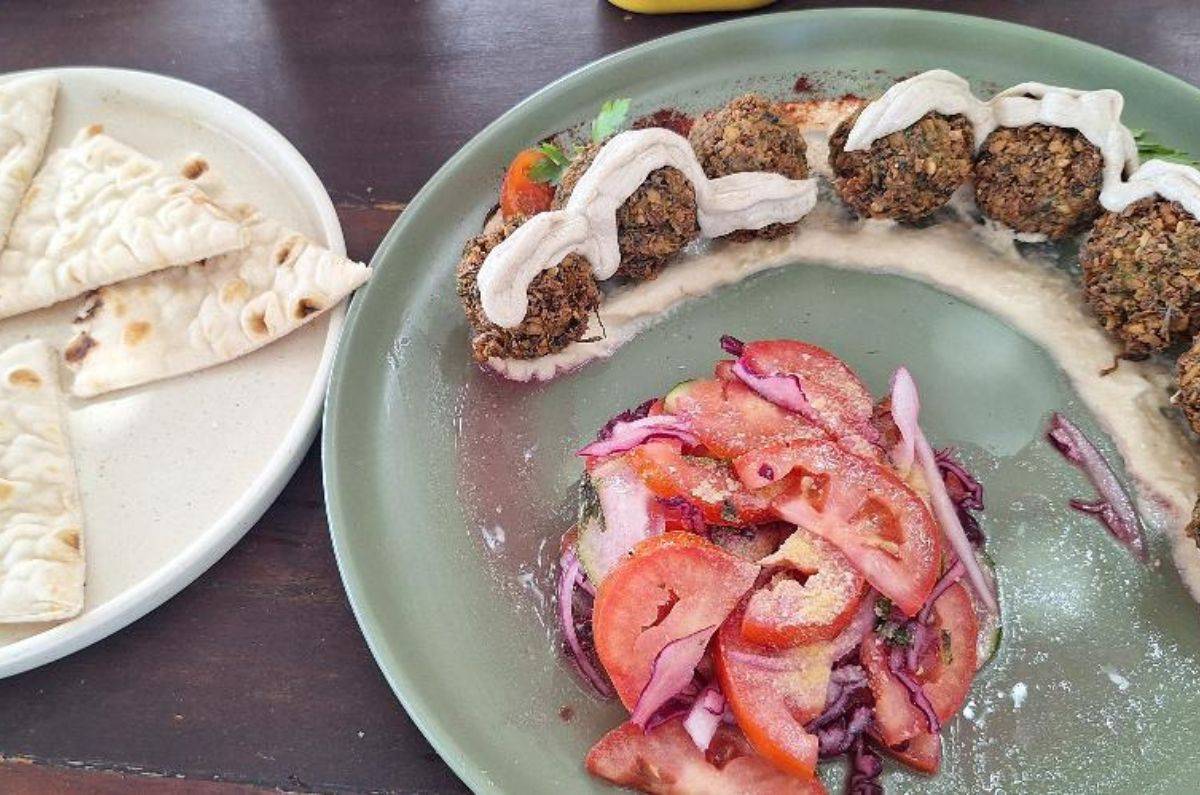 Croquetas de garbanzo libanesas servidas sobre hummus, ensalada de pepino, cebolla morada y jitomate en La Embajada Universal, foto de Miriam Carmo