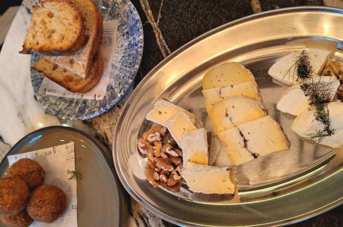 Croquetas de pato confitado con holandesa de porro, pan de masa madre y tabla de quesos locales, foto de Miriam Carmo