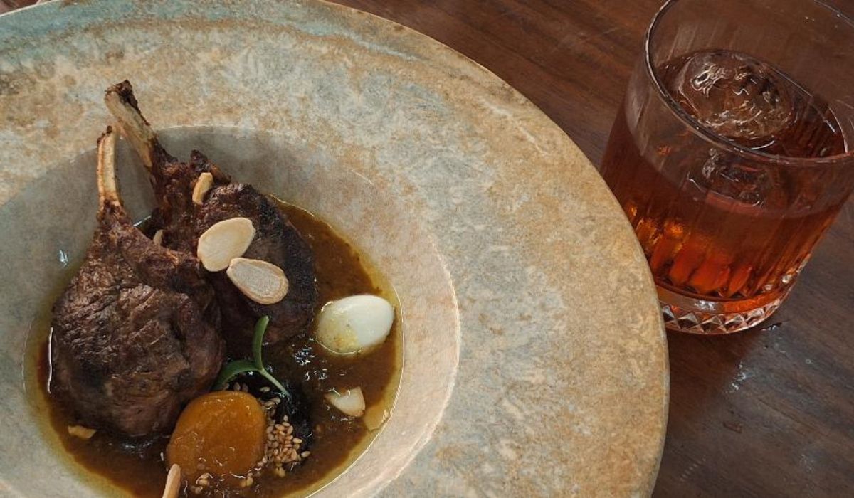 Tajín de cordero aromatizados con azafrán, chabacano y ciruela caramelizada, acompañado de almendra tostada y huevo de codorniz con cóctel Amarre (Gin Gato Madre infusionado con cacao, Carpano y un toque salino), foto de Miriam Carmo