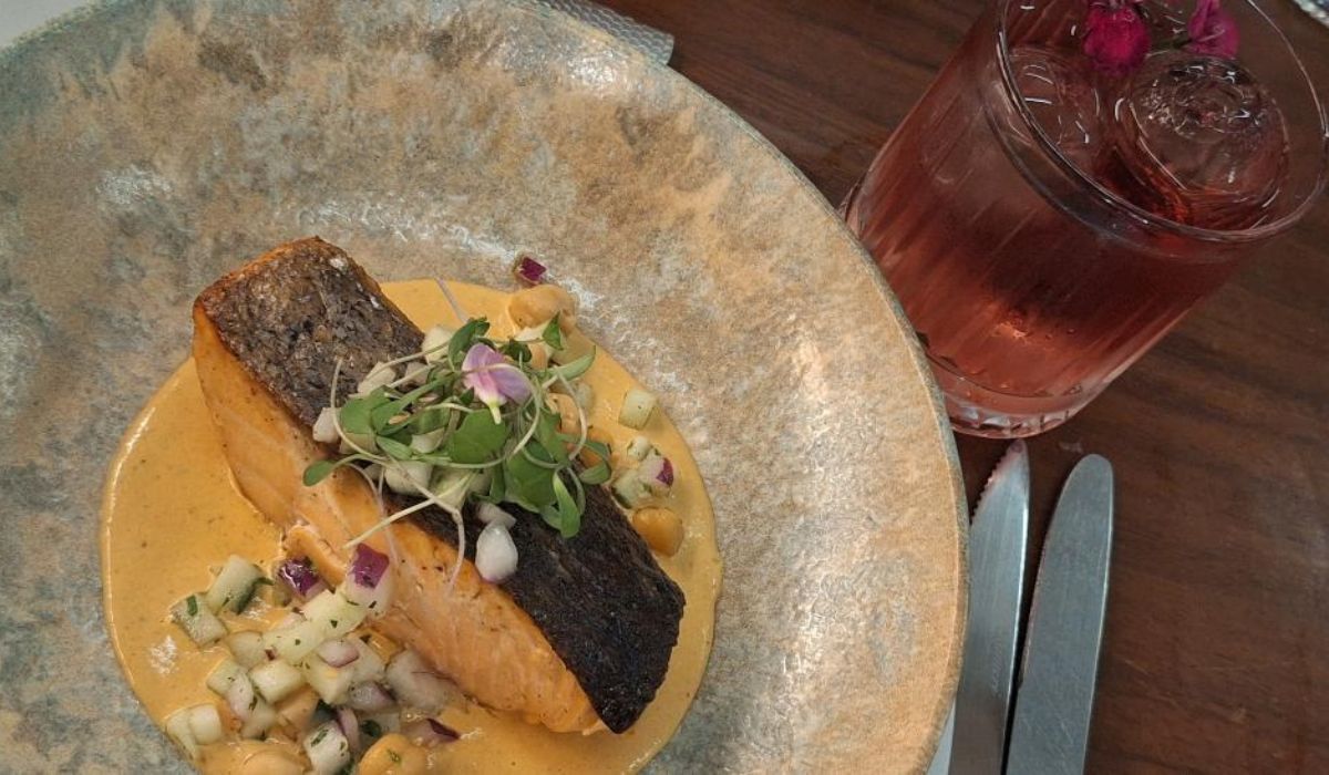 Robalo sellado, ensalada de garbanzos penoli y mango, beurre blanc de tres chiles con cóctel floral (Gin Solferino, flor de sauco, infusión de Manzanilla, aromatizado con toronja), foto de Miriam Carmo